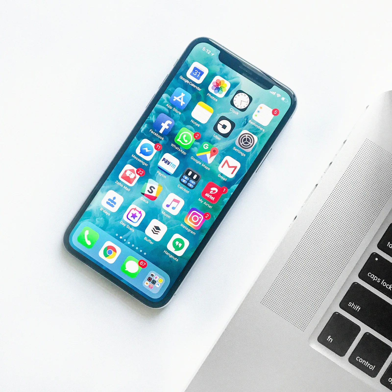 A smartphone lying beside a Macbook